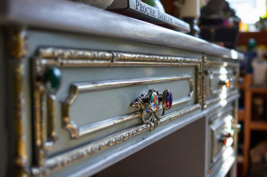 Poignée ornementale sur un meuble gris et doré