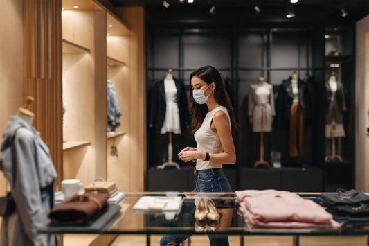 Femme masquée dans une boutique de vêtements élégante